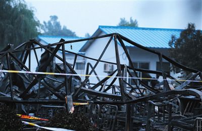 昨日，河南省鲁山县，康乐园老年公寓，彩钢房被烧得只剩下骨架，堆积着。远处，是该公寓两座没有过火的彩钢房。