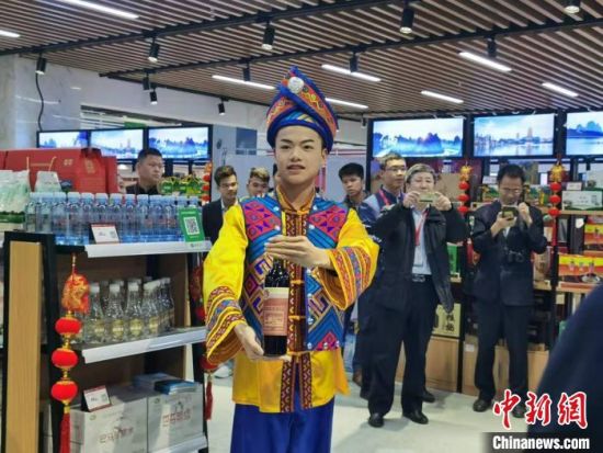 广西小伙推荐家乡的产品。　郑小红 摄
